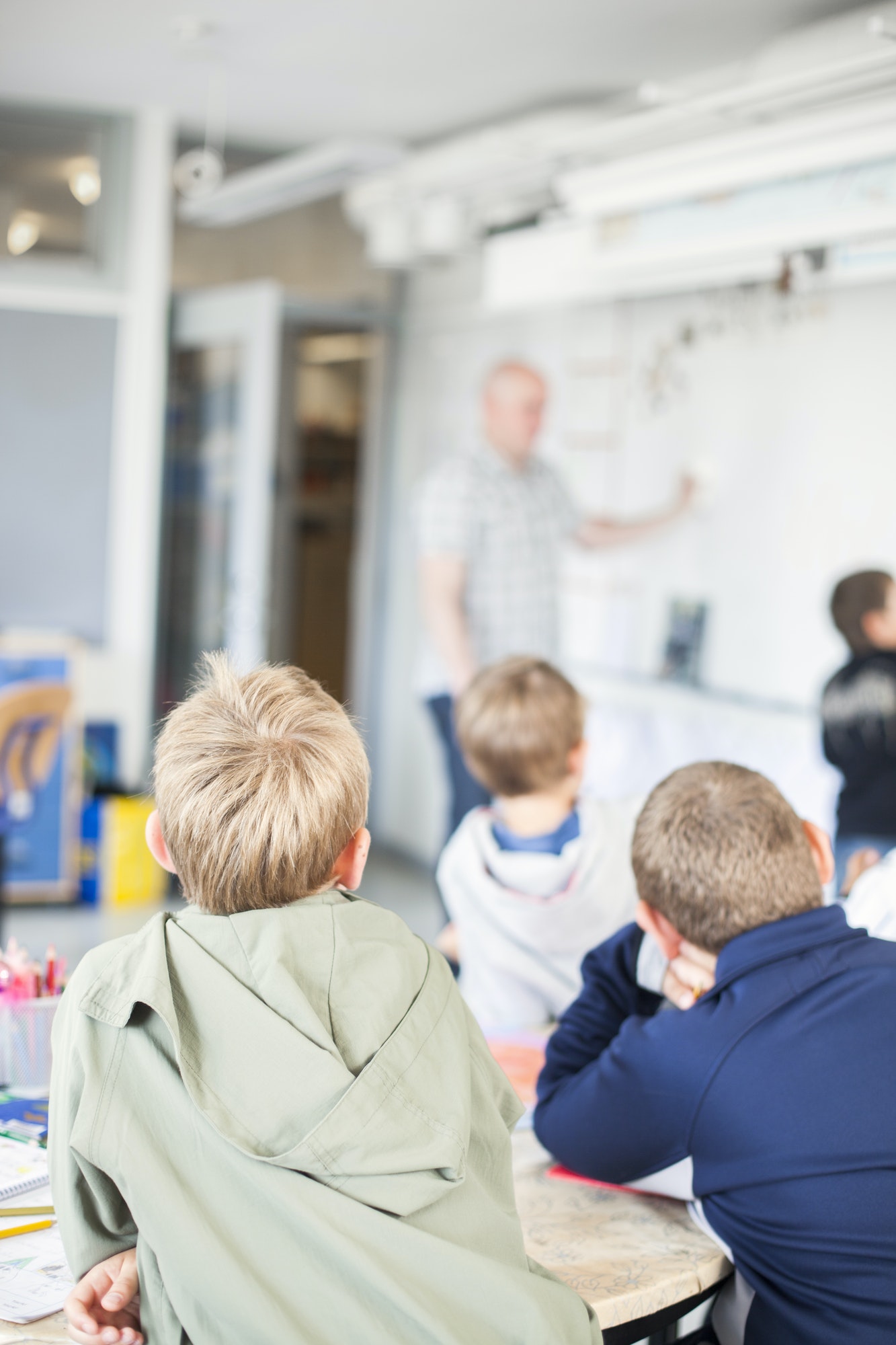 Children looking at teacher during lecture in classroom